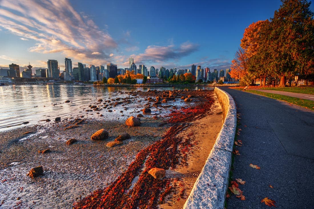 Vue sur le centre-ville de Vancouver depuis le parc Stanley, avec les montagnes enneigées en arrière-plan